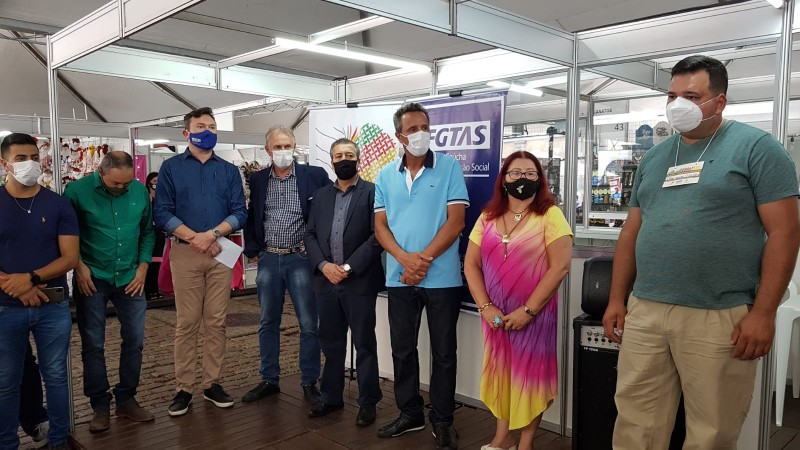 Secretário Ronaldo Nogueira com mais sete pessoas em pé, prestigiando a abertura oficial da ARTESUL. Seis homens, de calça,casaco e camisa e uma mulher de vestido colorido.
