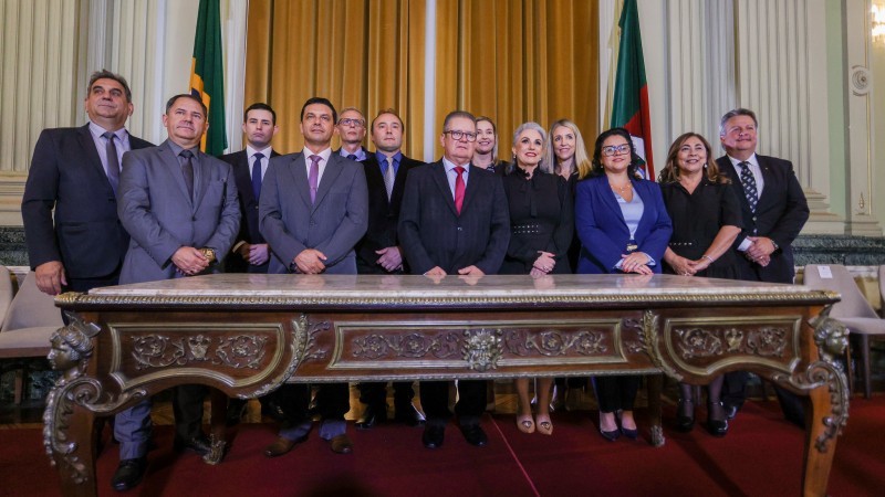 Novos Secretários, foto atrás da mesa do Palácio Piratini, oito homens de terno e gravata e cinco mulheres.