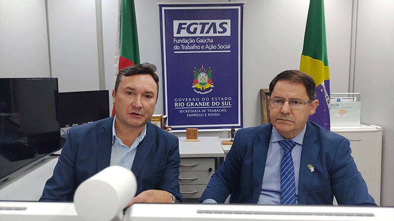 Dois homens sentados em frente ao computador