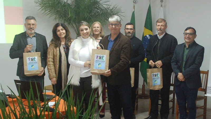 5 homens e 3 mulheres recebendo um presente e tirando uma foto