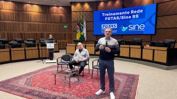 Foto de audit&oacute;rio com o secret&aacute;rio Scorsatto em p&eacute; falando ao microfone
